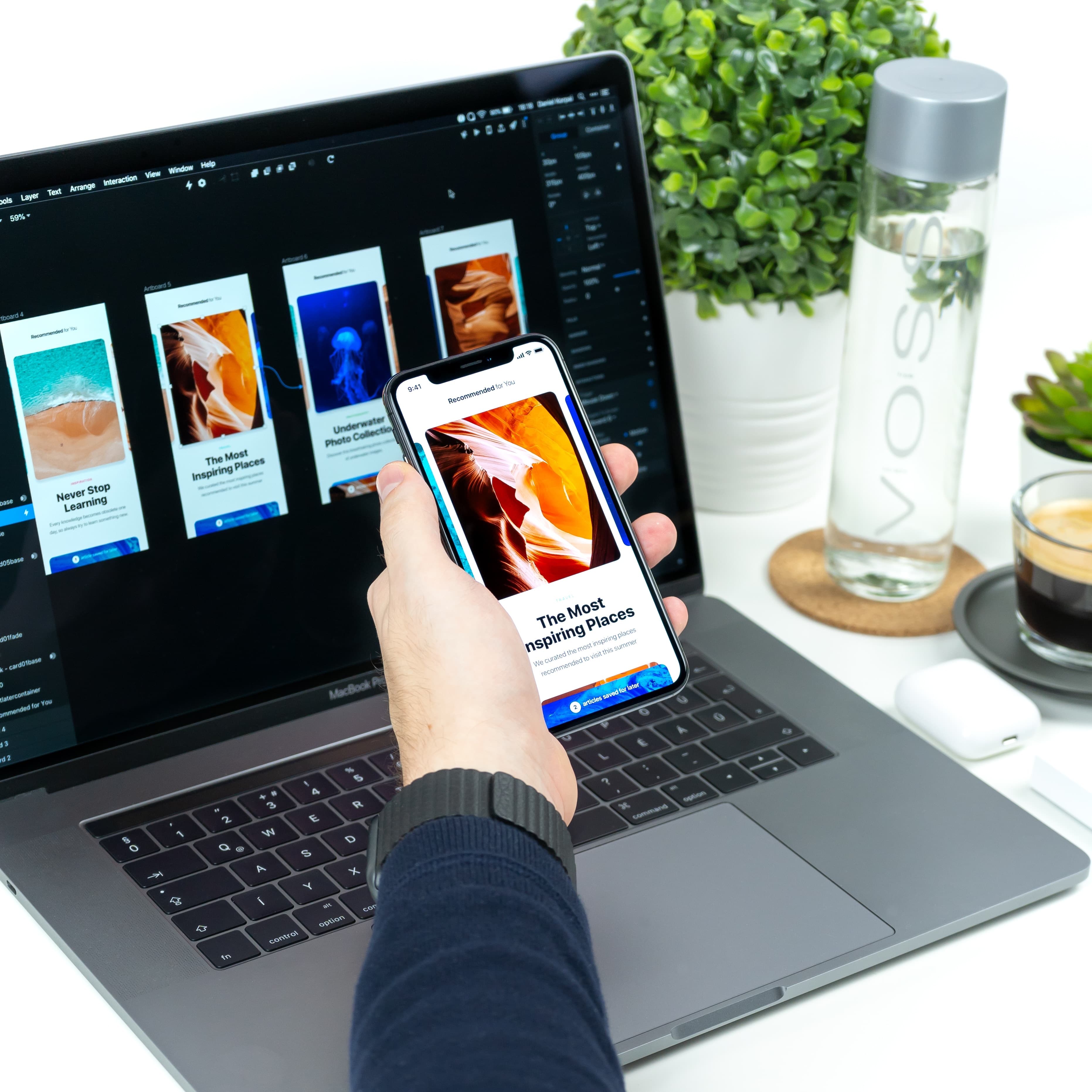 Ein Laptop mit laufender Design Software vor dem ein Handy mit geöffneter App gehalten wird.